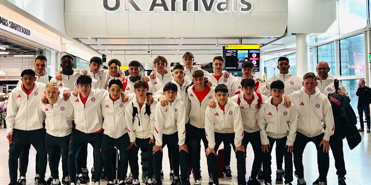 Die FC Bayern U16 posiert für ein Teamfoto am Flughafen.