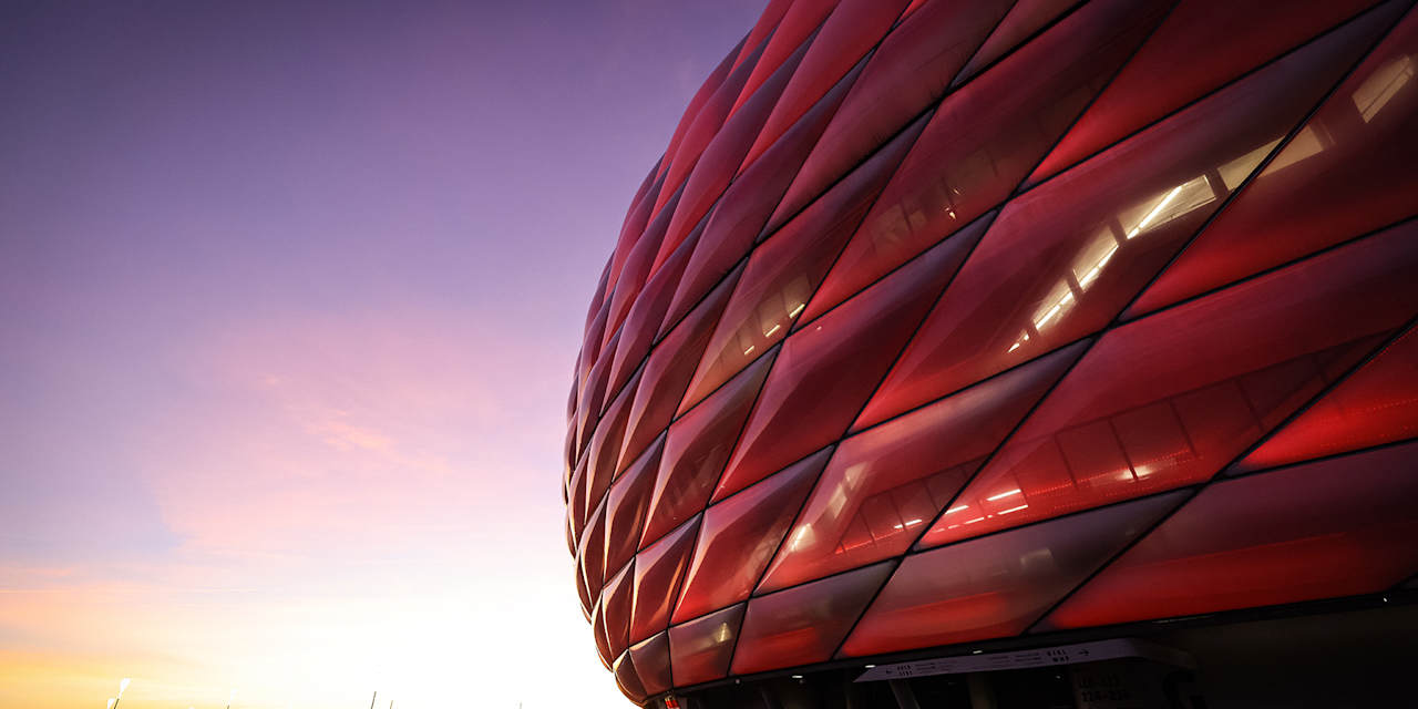 Rote Fassade der Allianz Arena im Abendhimmel
