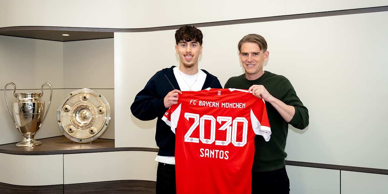 David Santos Daiber und Christoph Freund halten ein FC Bayern Trikot mit 2030 Santos hoch