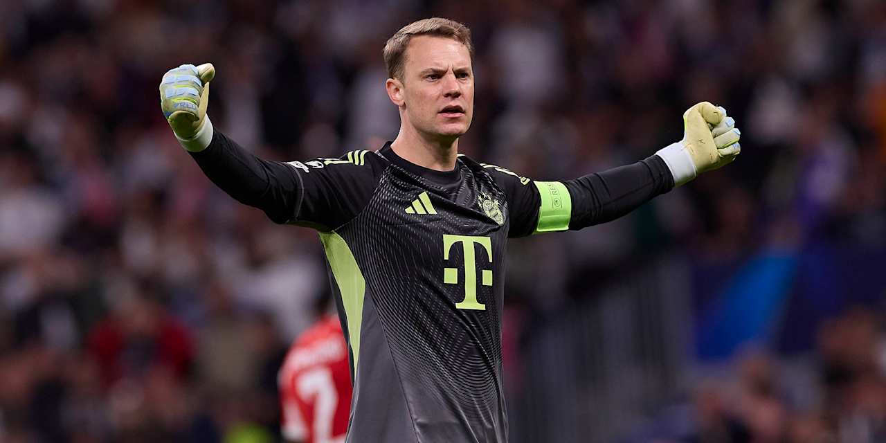 Manuel Neuer steht mit ausgebreiteten Armen und geballten Fäusten im Bernabeu