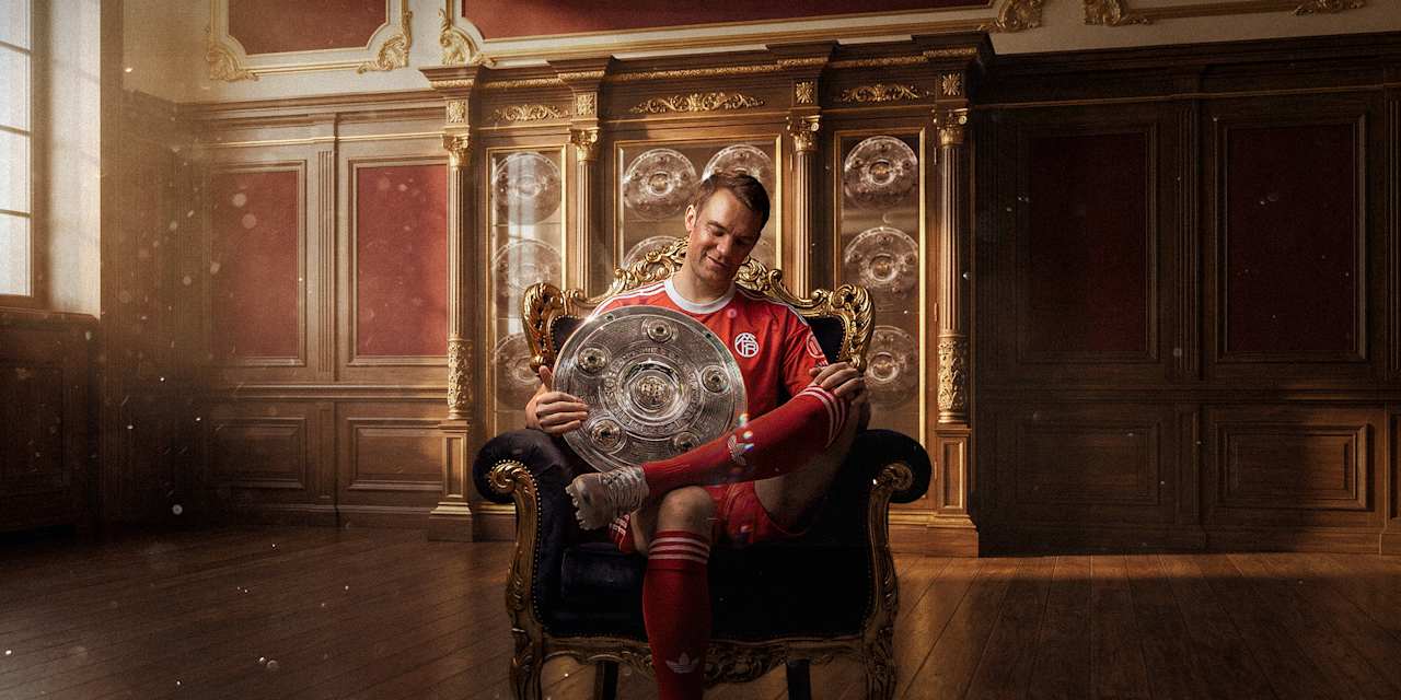 Manuel Neuer sitzt mit der Meisterschale in einem Sessel.