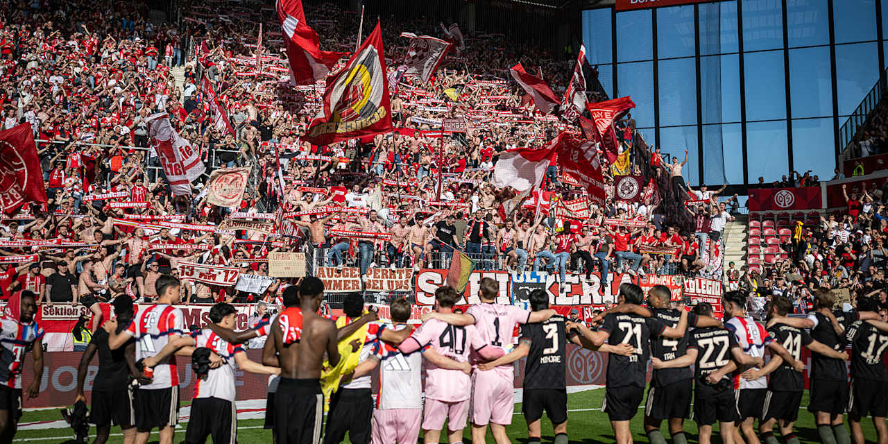 Spieler jubeln mit den Fans nach dem 4:3-Sieg im Bundesliga-Spiel des FC Bayern beim 1. FSV Mainz 05