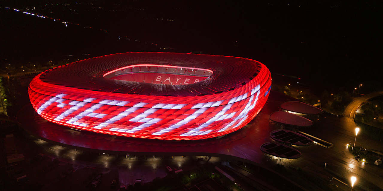 Allianz Arena leuchtet rot mit dem Schriftzug Meister auf der Fassade