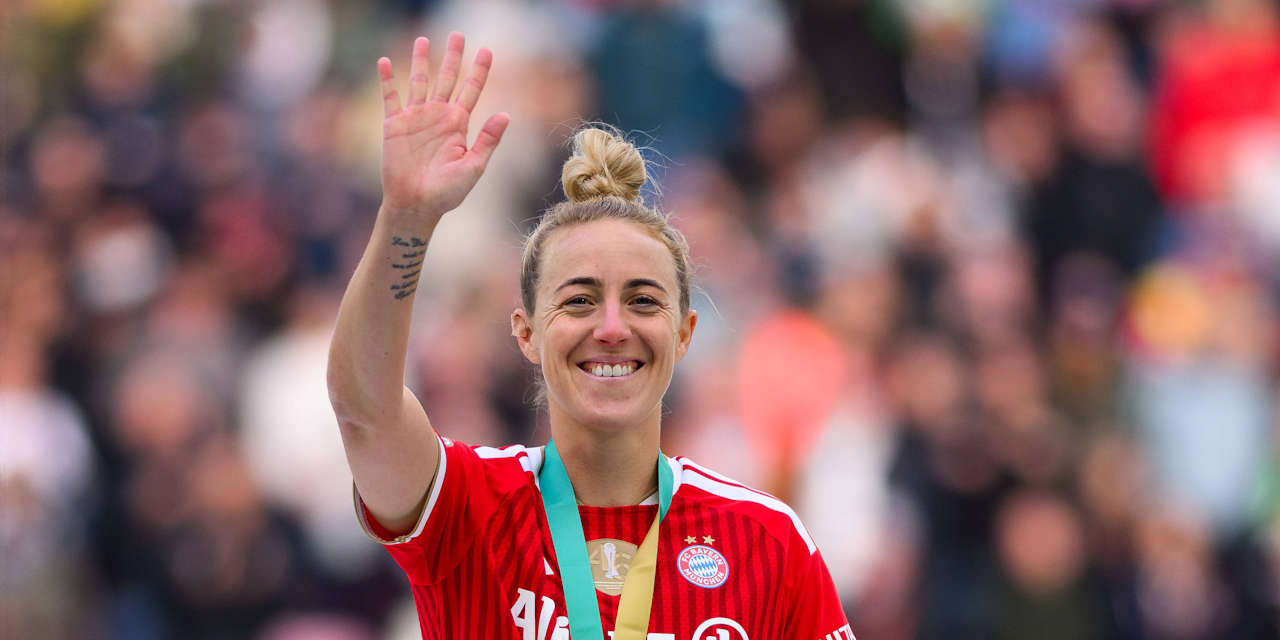 Carolin Simon winkt mit einem Lächeln und der DFB-Pokal-Goldmedaille um den Hals in Richtung Kamera.