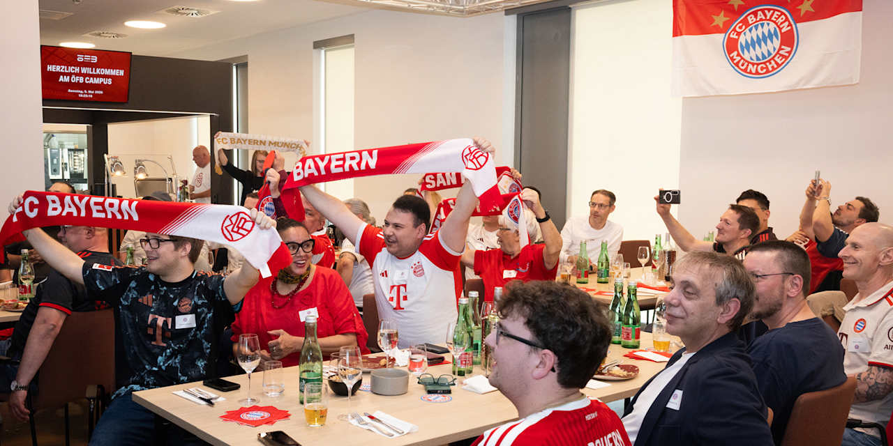 FC Bayern fans hold up their scarves at the members’ Stammtisch in Vienna