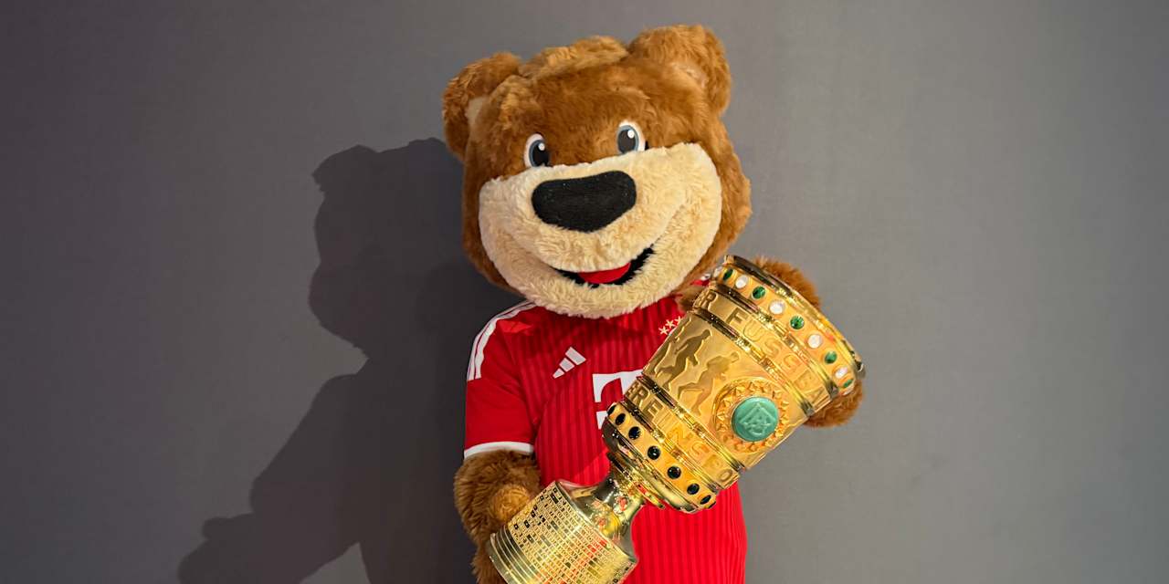 Berni steht mit dem DFB-Pokal vor einer Wand