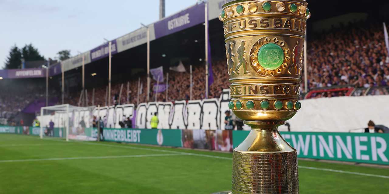 Die DFB-Pokal-Trophäe steht vor einer Tribüne auf dem Rasen im Stadion an der Bremer Brücke in Osnabrück