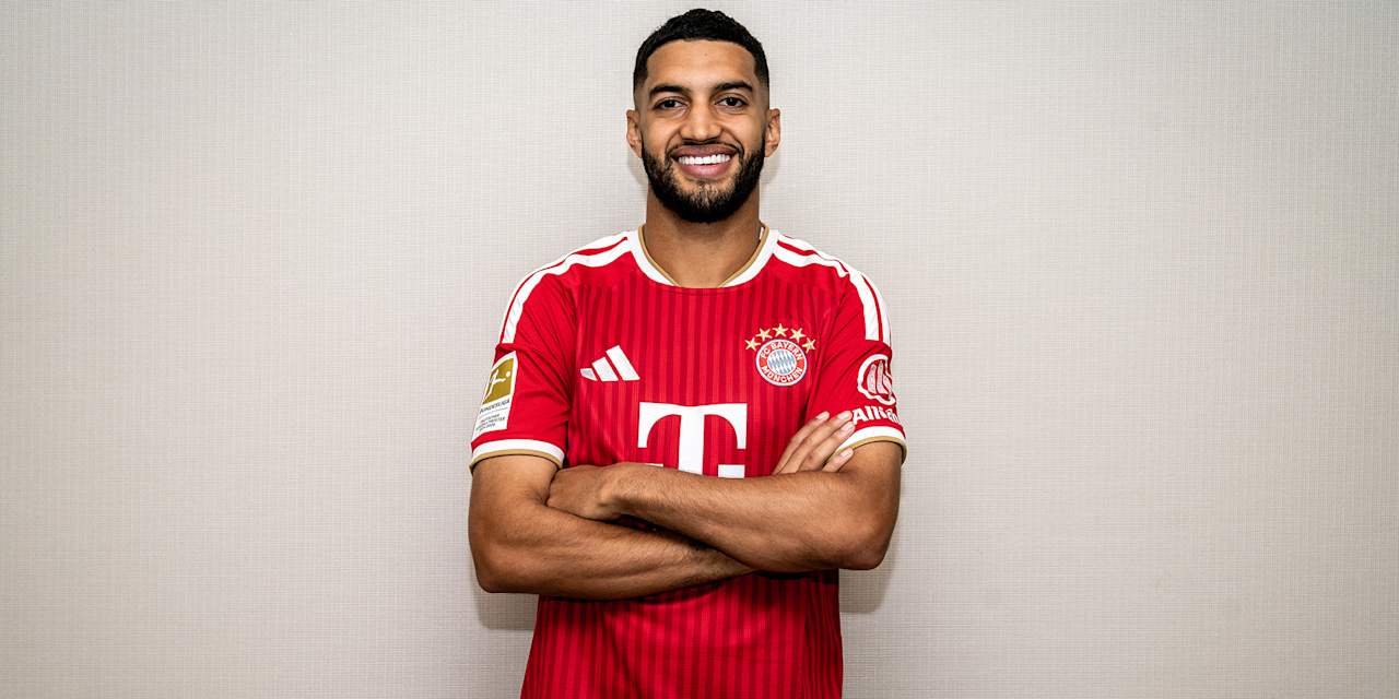 Ismael Saibari standing against a wall, smiling and wearing an FC Bayern shirt.