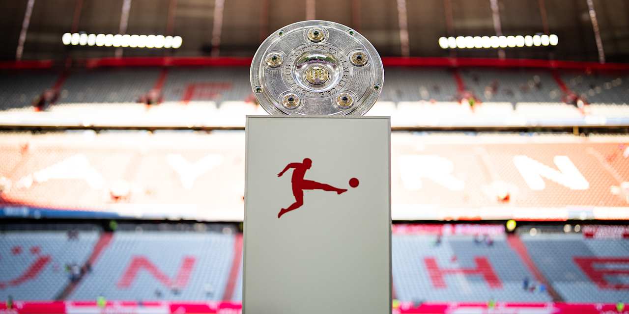 Meisterschale der Bundesliga auf einem Podest auf dem Rasen der Allianz Arena