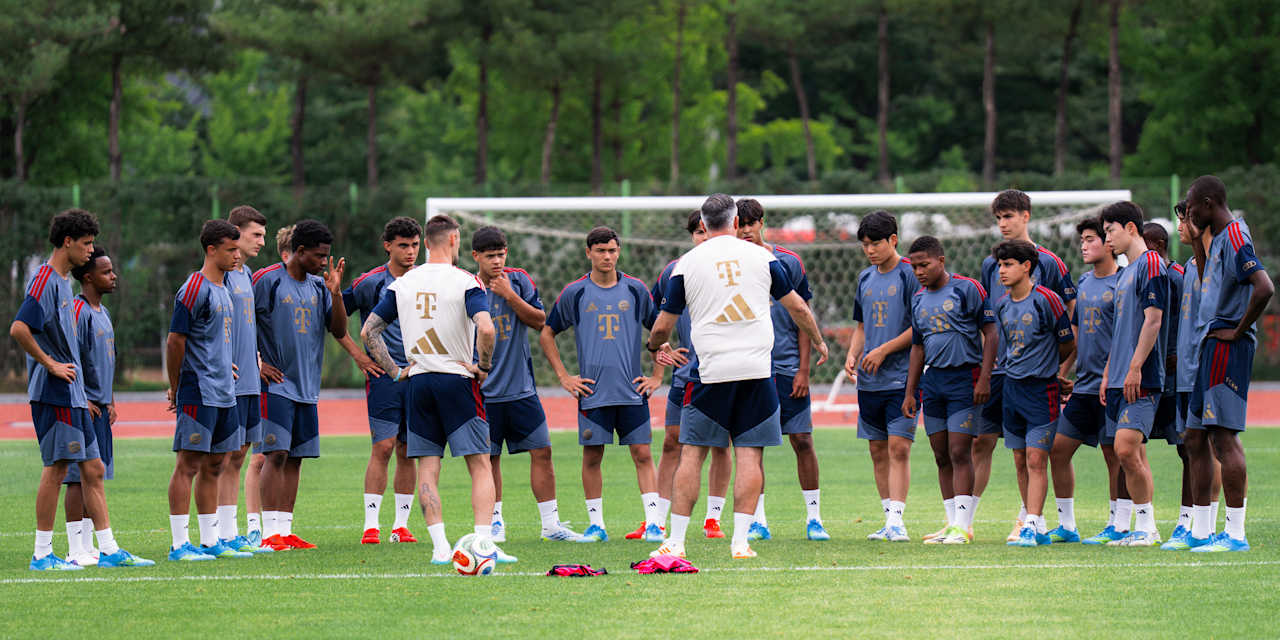 The coaches talking to the World Squad on the pitch.