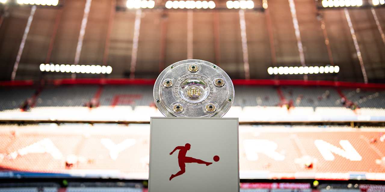 Die Meisterschale steht in der leeren Allianz Arena auf dem Rasen auf einem Podest