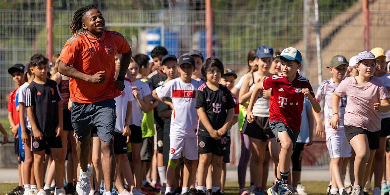 Wisdom Mike joggt mit Grundschülern beim Jugend trainiert-Programm des FC Bayern an der Säbener Straße
