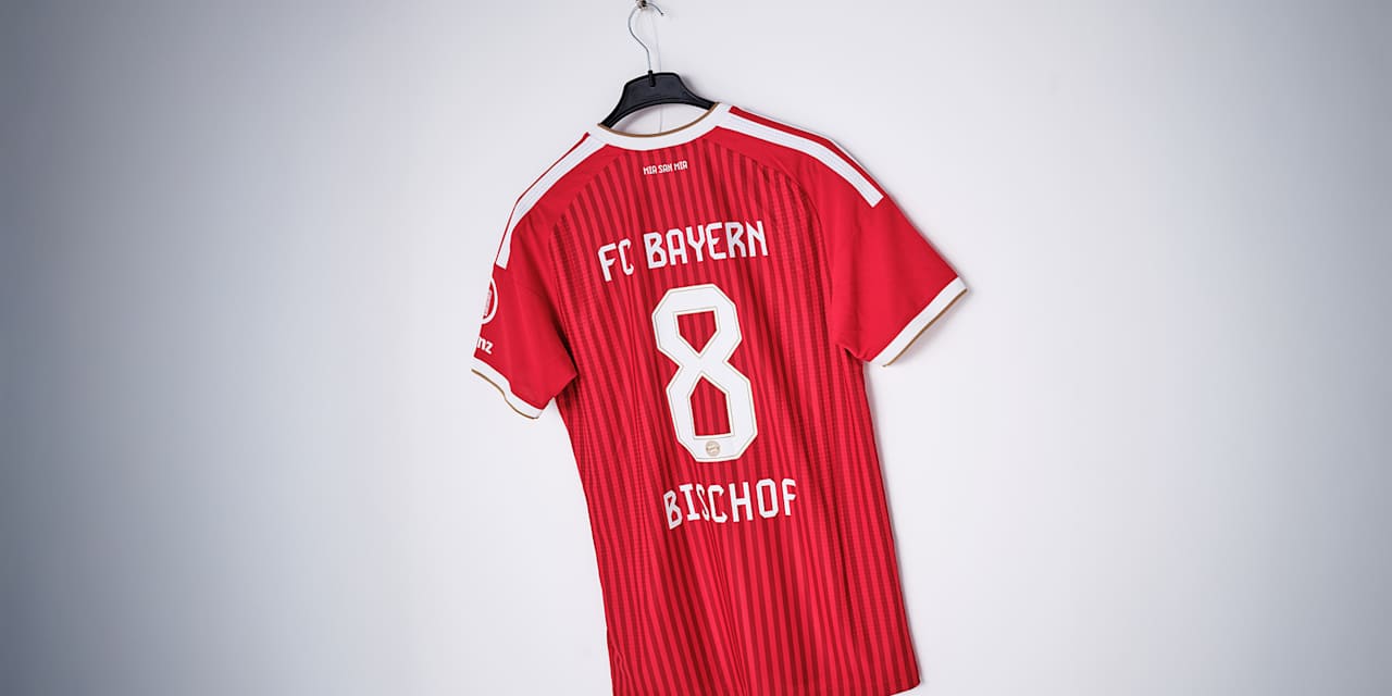 Das rote FC Bayern-Trikot von Tom Bischof mit der Nummer 8 hängt vor einer weißen Wand