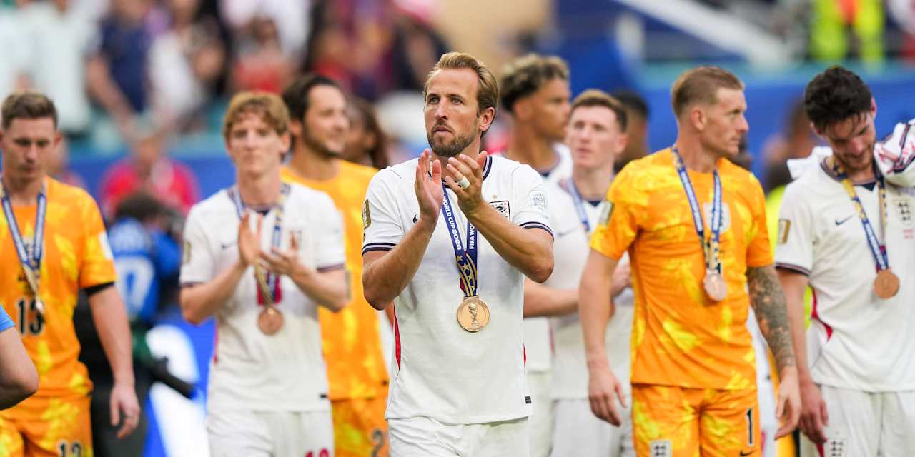 Harry Kane claps the fans with a bronze medal around his neck