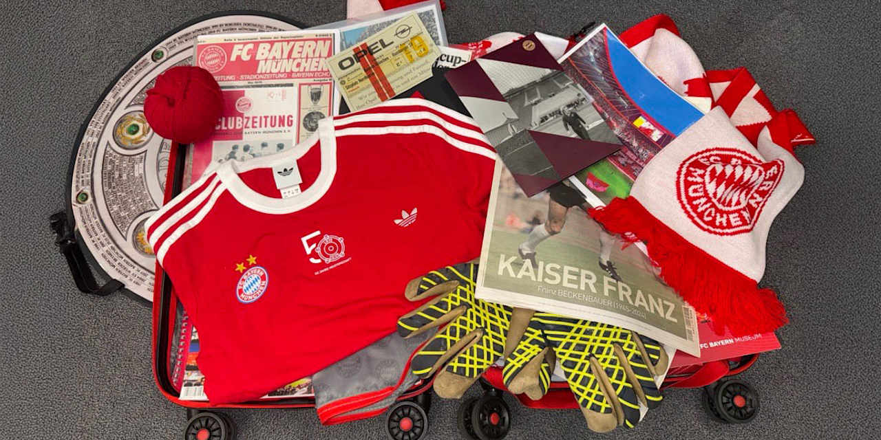 Ein Koffer, auf dem viele Bayern-Utensilien liegen: Trikots, Zeitungen, Tickets