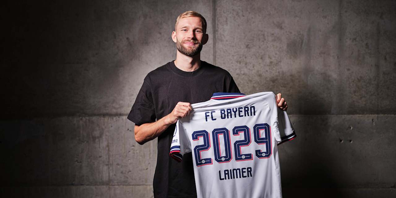 Konrad Laimer bei seiner Vertragsverlängerung mit dem weißen Trikot in der Hand.