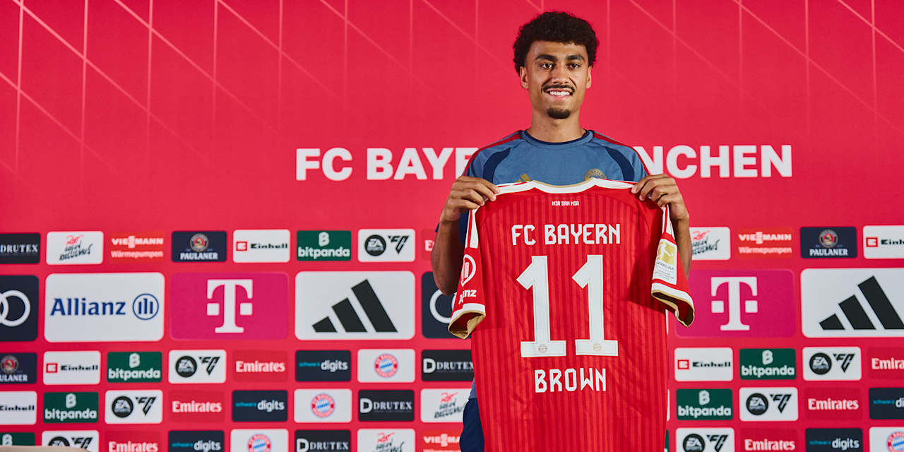 Nathaniel Brown hält nach dem Pressetalk sein FC Bayern Trikot mit der Nummer 11 hoch