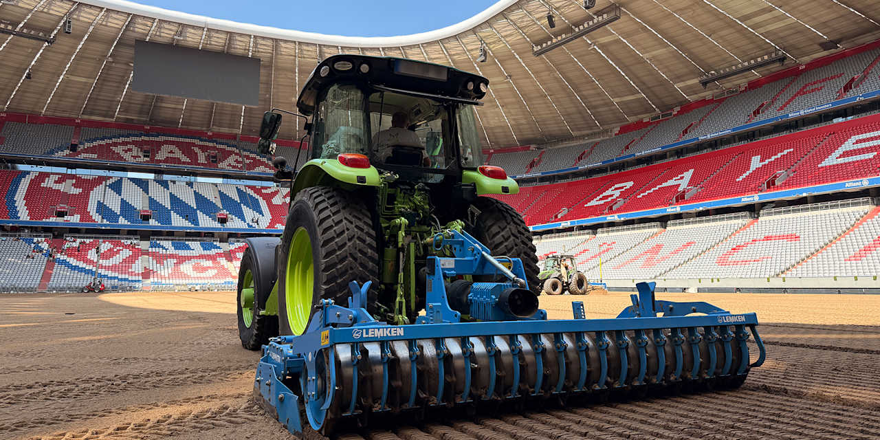Ein Traktor bearbeitet das brachliegende Spielfeld der Allianz Arena