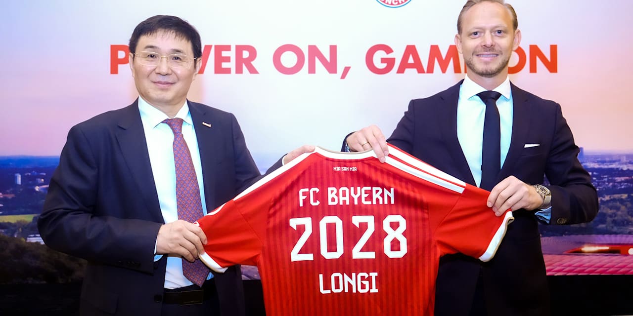Zhong Baoshen, presidente de LONGi, y Rouven Kasper, director de Marketing y Ventas del FC Bayern, sostienen una camiseta del FC Bayern con el estampado LONGi 2029.