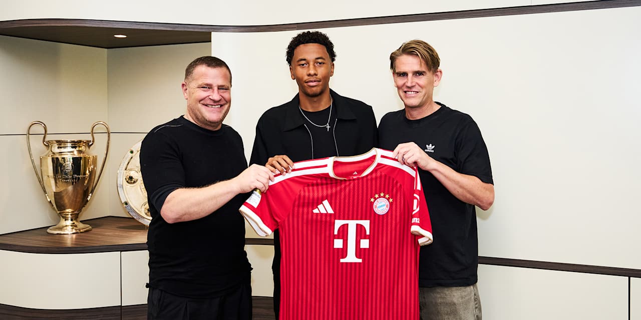 Max Eberl, Cassiano Kiala und Christoph Freund halten ein rotes FC Bayern Trikot