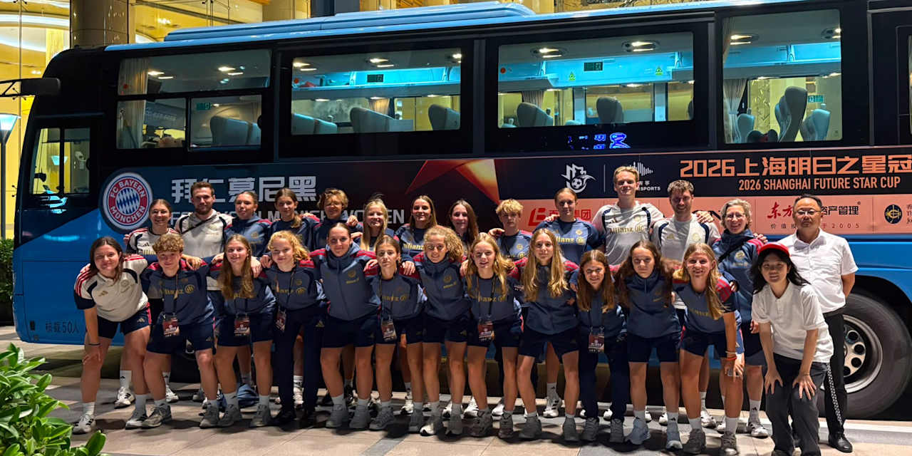 Die U17-Juniorinnen des FC Bayern posieren für ein Mannschaftsfoto vor einem Bus in Shanghai