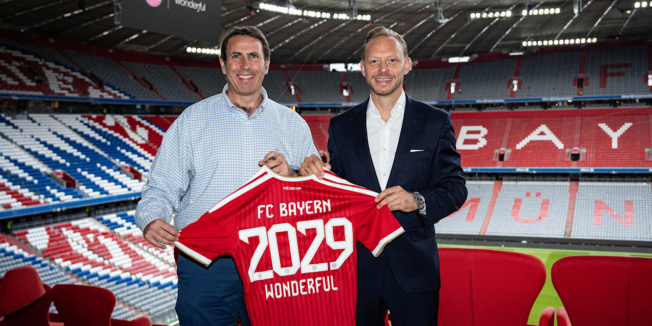 Rouven Kasper, Vorstand Marketing und Vertrieb FC Bayern, und Bar Winkler, Mitgründer und CEO von Wonderful, halten in der Allianz Arena ein FCB-Trikot mit 2029 Wonderful