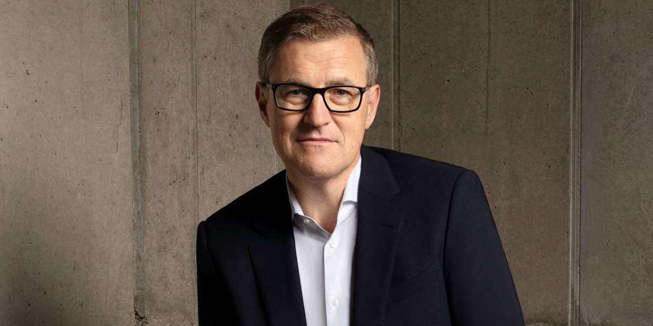 Jan-Christian Dreesen in front of a light-coloured wall.