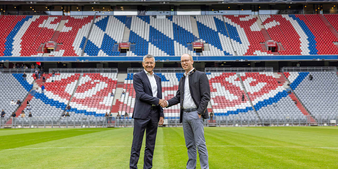 Herbert Hainer und Max Viessmann schütteln sich die Hände auf dem Rasen der Allianz Arena