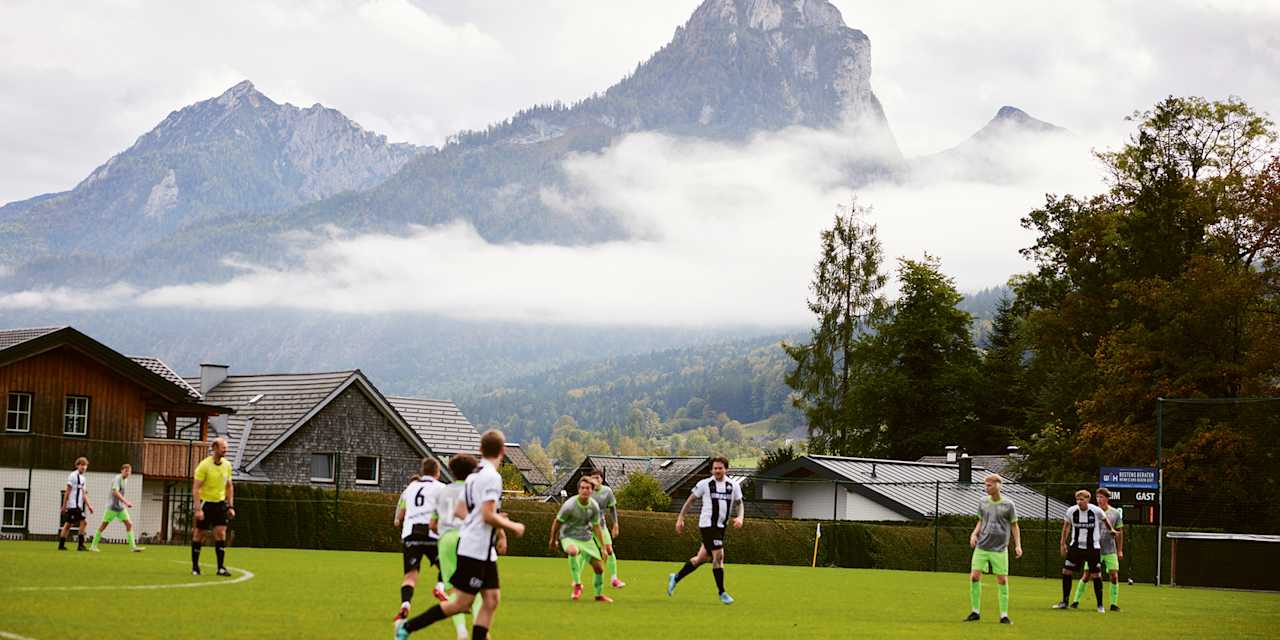 Jugendliche spielen Fußball auf dem Platz in Abersee, Österreich