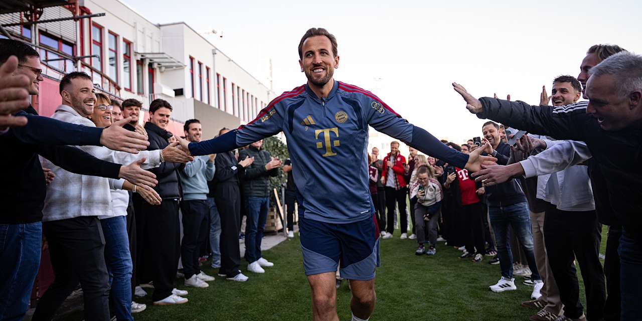 Harry Kane klatscht mit Mitarbeitern des FC Bayern auf dem Trainingsplatz ab