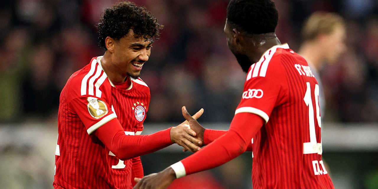 Nathaniel Brown und Alphonso Davies schlagen lachend ein nach dem 5:1 im DFB-Pokalspiel des FC Bayern gegen den 1. FC Magdeburg