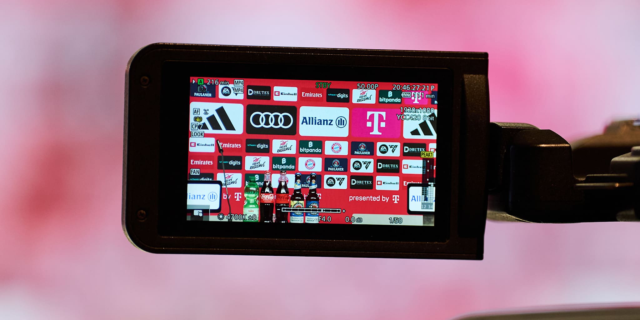 Auf dem Display einer Kamera ist die Sponsorenwand im Medienraum des FC Bayern zu sehen