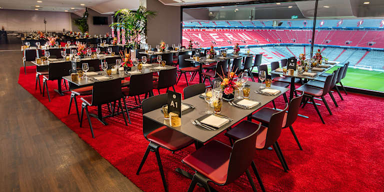 Eventbox - niedrige Tische vor Glasfront mit Blick ins Stadioninnere