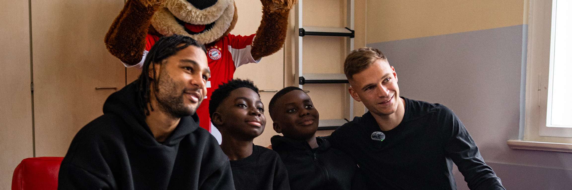 Joshua Kimmich und Serge Gnabry machen ein Foto mit zwei Kindern im Kinderkrankenhaus