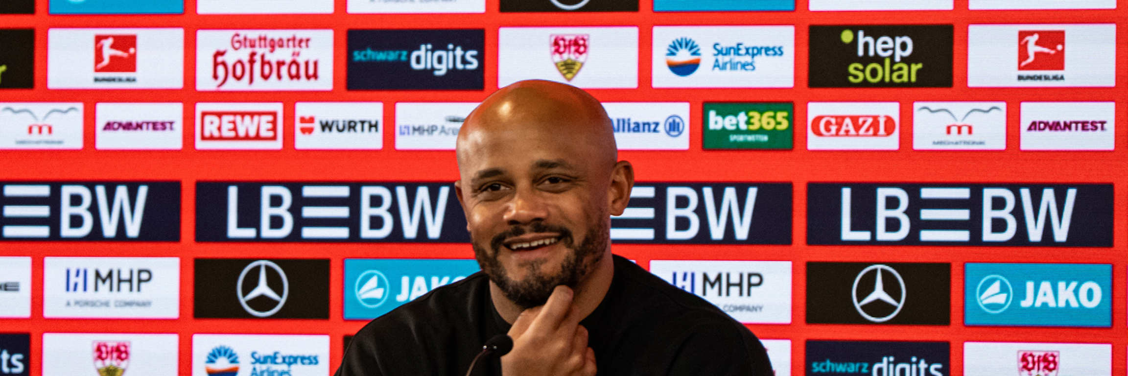 Vincent Kompany lächelnd auf der Pressekonferenz in Stuttgart