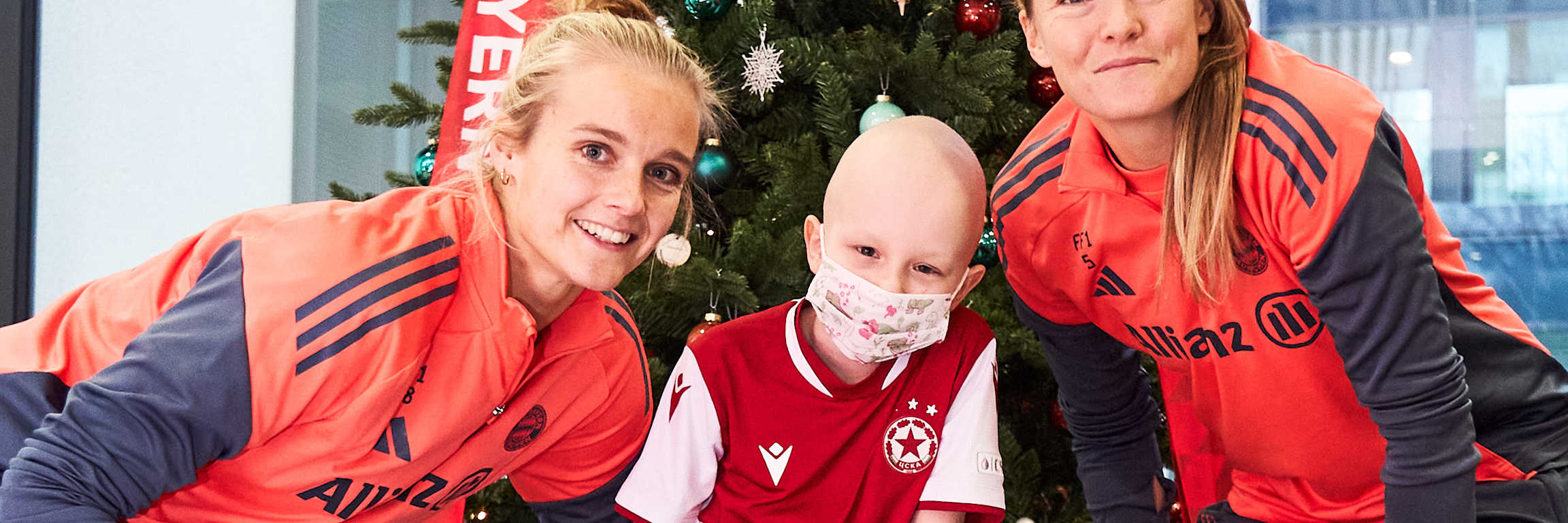 Anna Klink und Magdalena Eriksson machen ein Foto mit einem Kind.