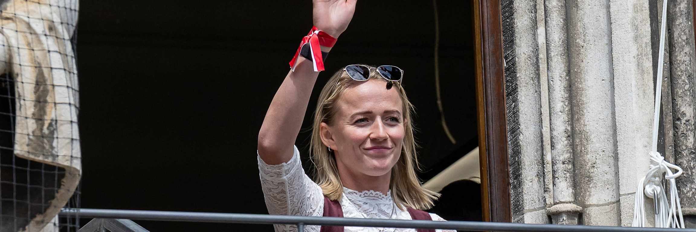 Lea Schüller winkt den Fans vom Münchner Rathausbalkon aus zu.