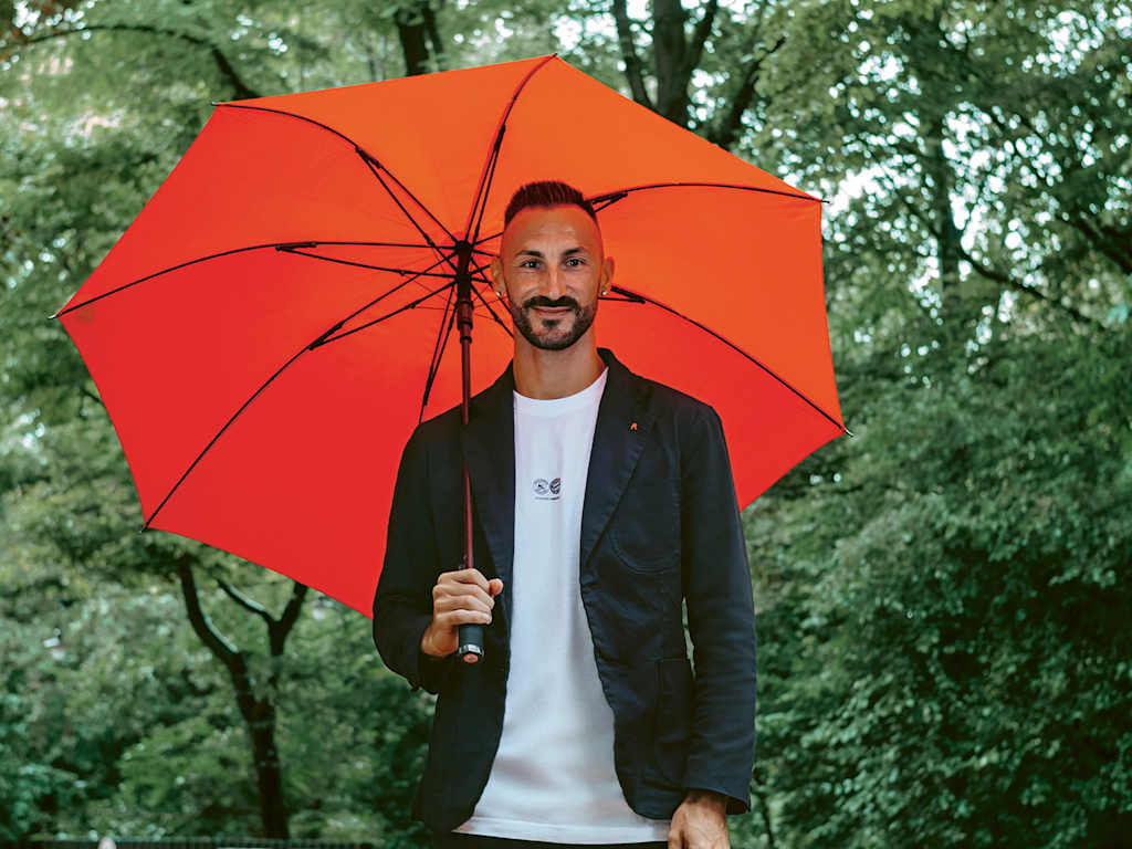 Diego Contento mit Regenschirm im Biergarten