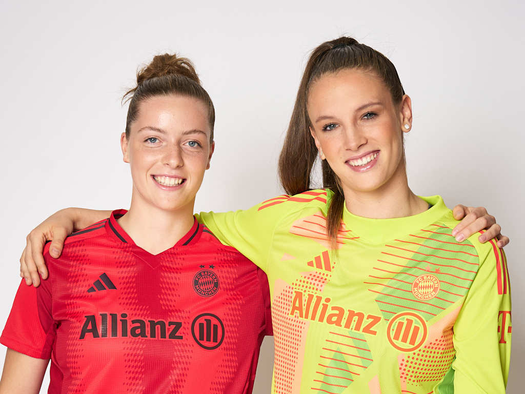 Porträt von Alara Şehitler und Ena Mahmutovic Arm in Arm mit dem FC Bayern Trikot und FCB-Torwarttrikot an.