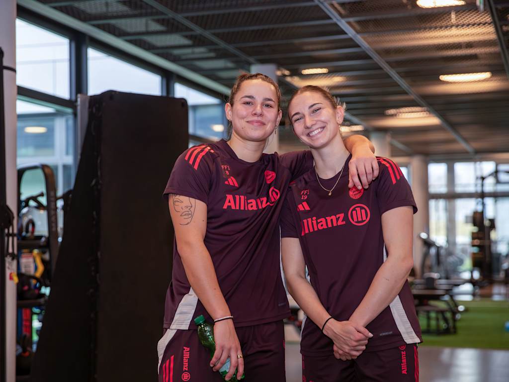 Porträt von Lena Oberdorf und Kathi Naschenweng Arm in Arm mit FC Bayern-Trainingsklamotten während der Reha am FC Bayern Campus.