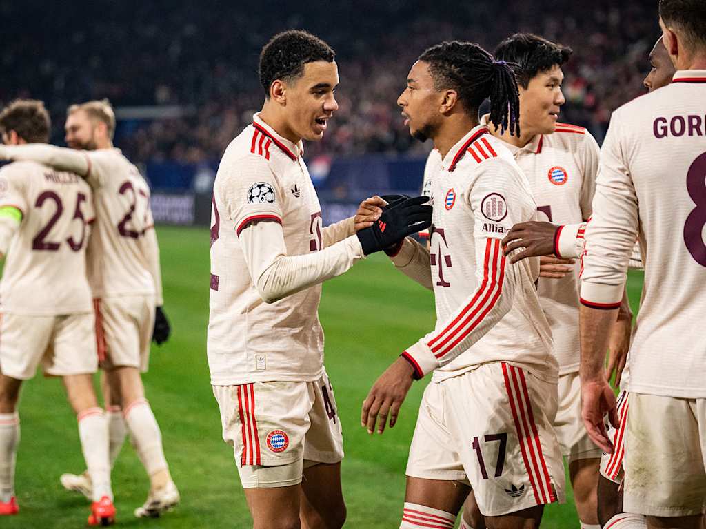 Jamal Musiala and Michael Olise celebrate after FC Bayern score against Shakhtar Donetsk.