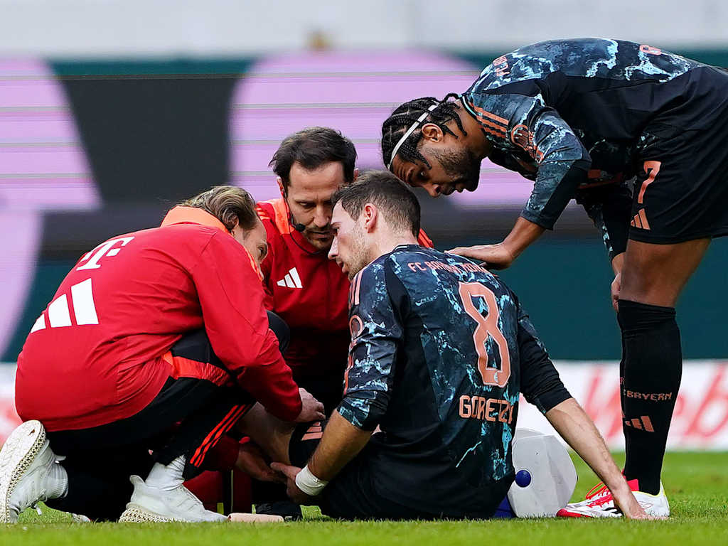 Leon Goretzka sitzt nach seiner Verletzung enttäuscht auf dem Rasen von Freiburg.