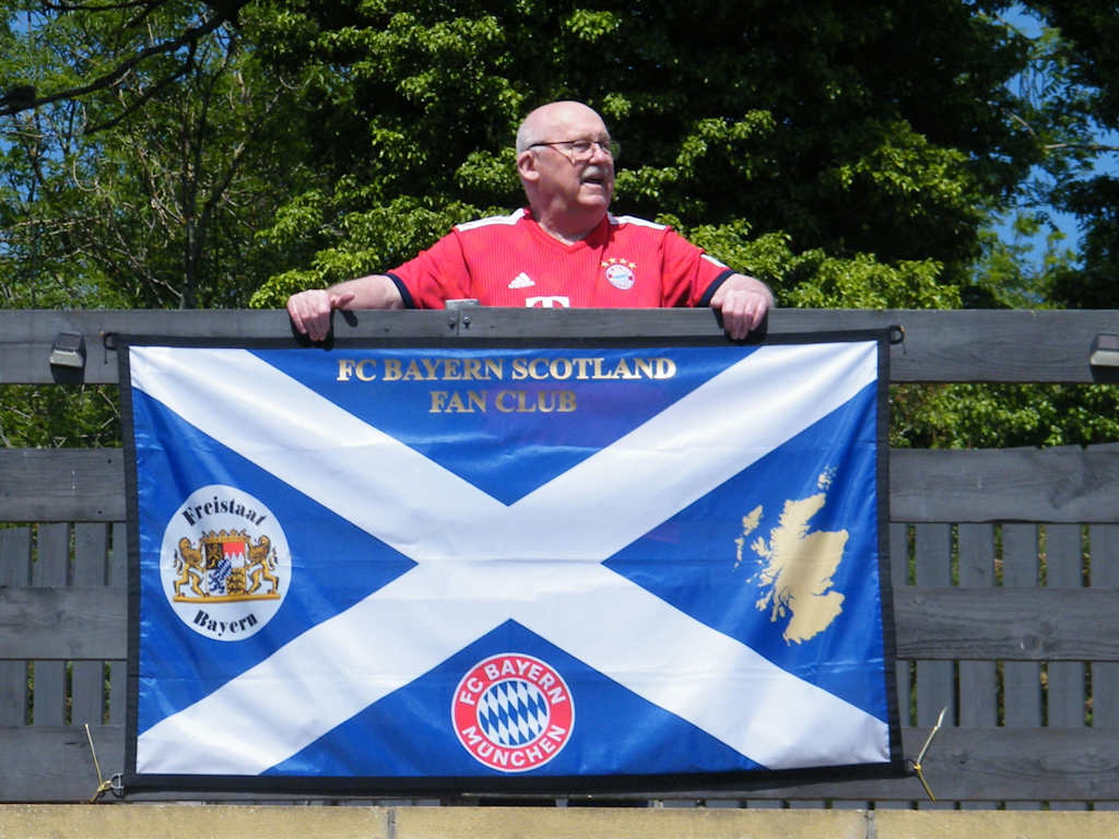 FC Bayern-Fan Drew vor einer schottischen Flagge