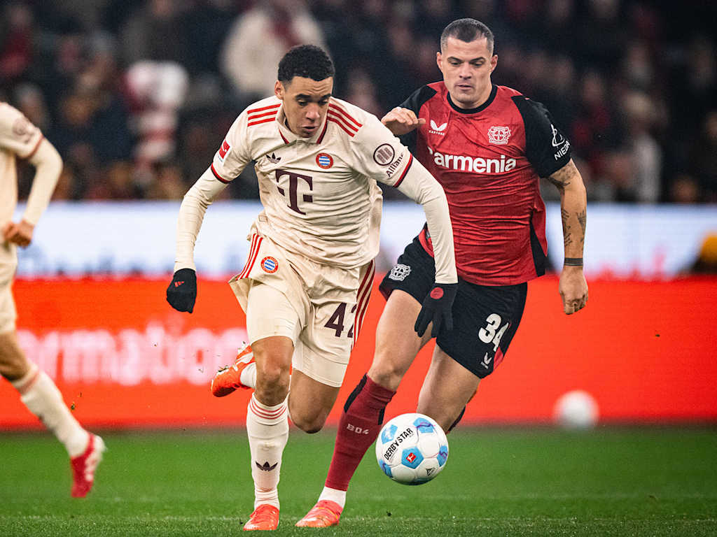 Jamal Musiala im Zweikampf mit Granit Xhaka im Bundesliga-Spiel des FC Bayern in Leverkusen.
