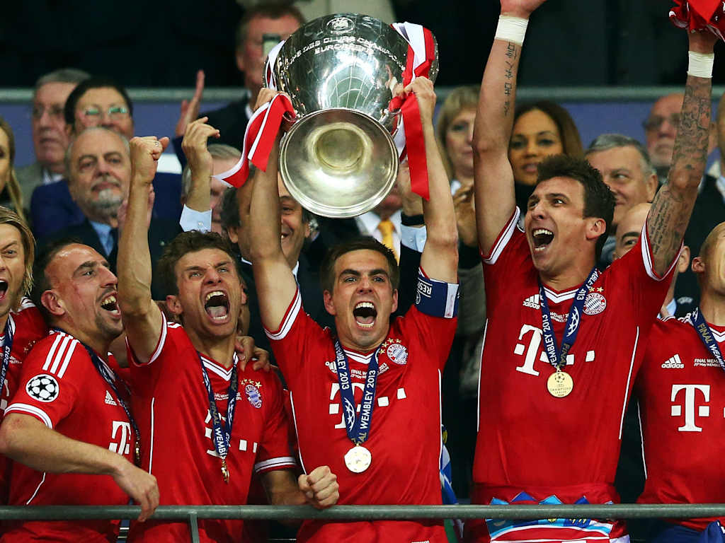 Philipp Lahm, Thomas Müller und weitere Spieler des FC Bayern jubeln nach dem gewonnenen Champions League-Finale 2013 gegen Borussia Dortmund in Wembley mit dem Pokal.