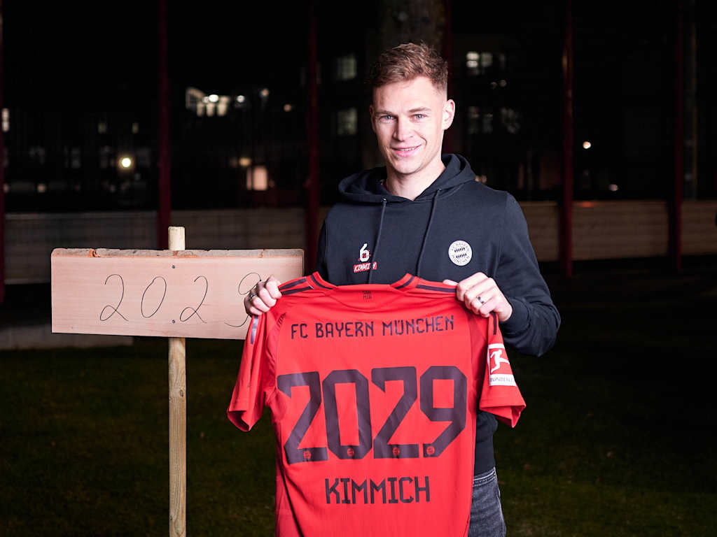 Joshua Kimmich steht mit dem Trikot in der Hand neben seinem geplanzten Baum