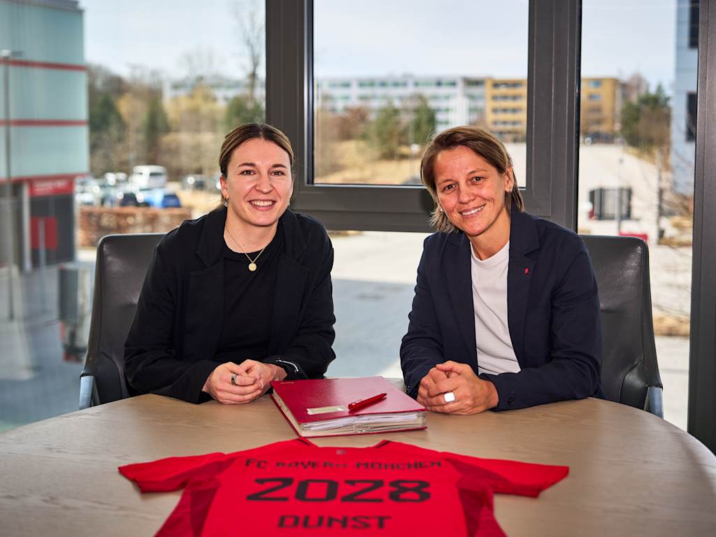 Barbara Dunst und Bianca Rech sitzend bei der Vertragsunterschrift am FC Bayern Campus.