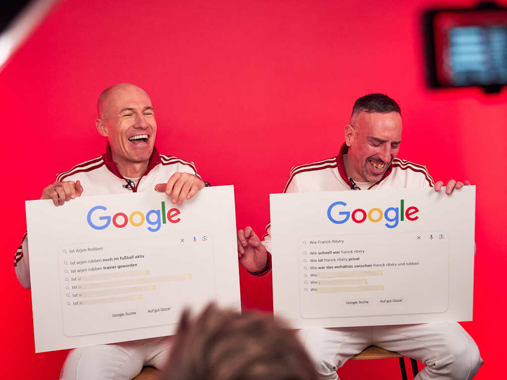 Arjen Robben and Franck Ribéry sit next to each other and laugh.