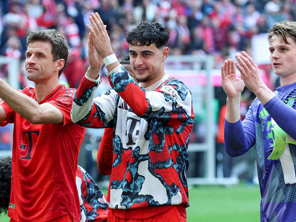 Thomas Müller, Aleks Pavlovic und Jonas Urbig klatschen in Richtung der Fans.