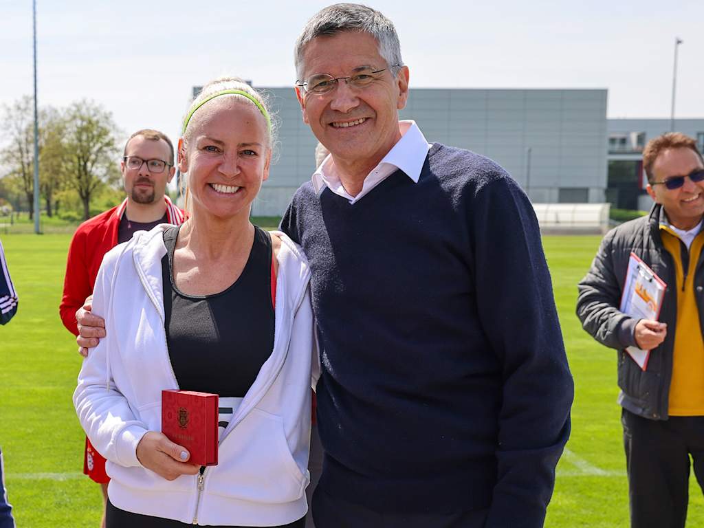 Herbert Hainer puts his arm around a member at an FC Bayern event for the German Sports Badge